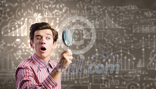 Young man scientist looking in magnifying glass Young man scientist looking in magnifying glass
