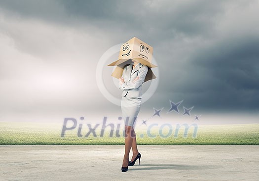 Businesswoman in suit wearing carton box on head Businesswoman in suit wearing carton box on head