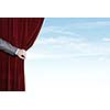 Hand of businessman opening red velvet curtain