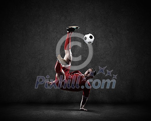 Football player kicking ball against dark background Football player kicking ball against dark background