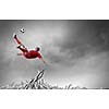 Football player in jump kicking the ball supported by fans