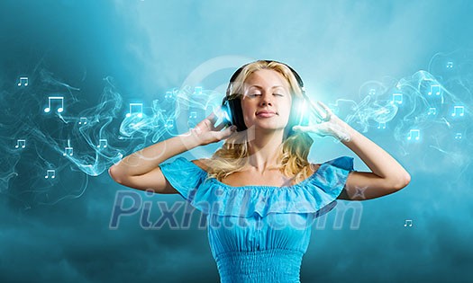Young blond girl in blue dress listening music Young blond girl in blue dress listening music