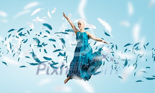 Young attractive woman in blue dress jumping high Young attractive woman in blue dress jumping high