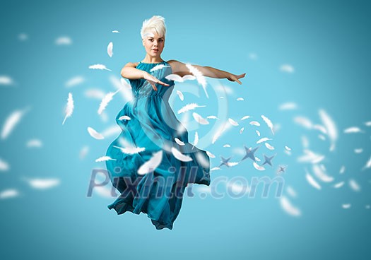 Young attractive woman in blue dress jumping high Young attractive woman in blue dress jumping high