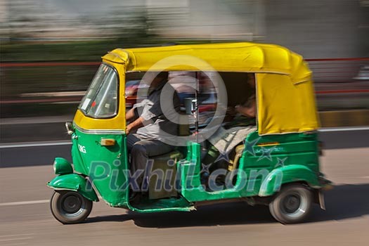Indian auto (autorickshaw) taxi in the street. Motion blur. Delhi, India Indian auto (autorickshaw) taxi in the street. Motion blur. Delhi, India