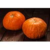 Two orange pumpkins on wooden background