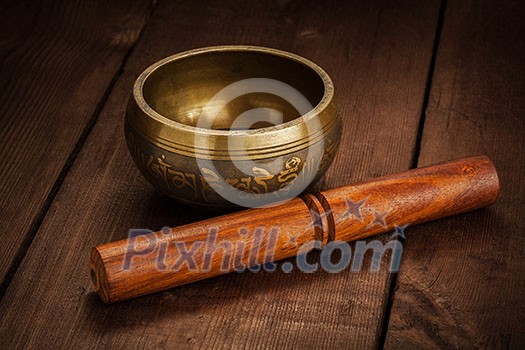 Tibetan buddhist singing bowl, rin gong, Himalayan bowl or suzu gong for meditation, music, relaxation, and personal well-being with mallet on wooden background Tibetan buddhist singing bowl, rin gong, Himalayan bowl or suzu gong for meditation, music, relaxation, and personal well-being with mallet on wooden background