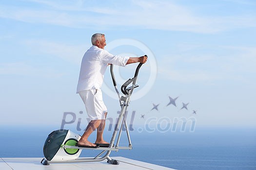 healthy senior man working out on gym treadmill machine at modern home terace with ocean view healthy senior man working out on gym treadmill machine at modern home terace with ocean view