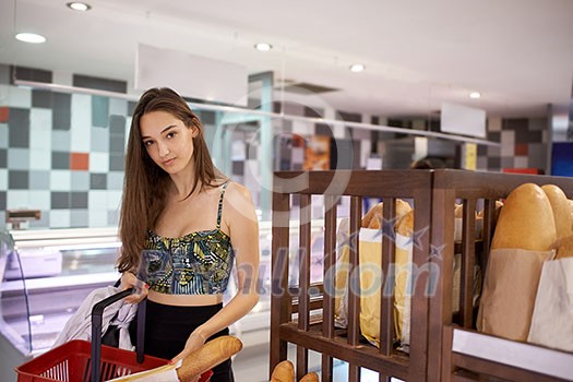young woman shopping for fruits and vegetables in produce department of a grocery store supermarket young woman shopping for fruits and vegetables in produce department of a grocery store supermarket