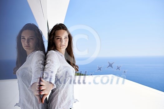 relaxed young beautiful woman in front of luxury modern home villa on balcony on sunny day relaxed young beautiful woman in front of luxury modern home villa on balcony on sunny day
