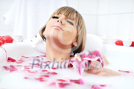 woman beauty spa and wellness treathment with red flower petals in bath with milk woman beauty spa and wellness treathment with red flower petals in bath with milk