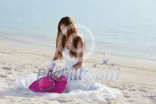 asian bride with a veil on the beach in the sky and blue sea. honeymoon on the fantastic island at summer asian bride with a veil on the beach in the sky and blue sea. honeymoon on the fantastic island at summer