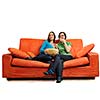 female friends eating popcorn and watching tv at home on orange sofa isolated on white