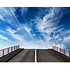 Asphalt road going into sky with clouds