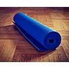 Vintage retro effect filtered hipster style image of Yoga mat on wooden floor