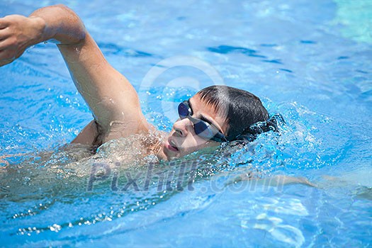 Young man swimming the front crawl in a pool Young man swimming the front crawl in a pool