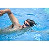 Young man swimming the front crawl in a pool