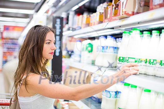 Beautiful young woman shopping in a grocery store/supermarket (color toned image) Beautiful young woman shopping in a grocery store/supermarket (color toned image)