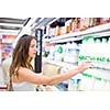 Beautiful young woman shopping in a grocery store/supermarket (color toned image)