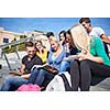 Group portrait  of happy  students outside sitting on steps have fun