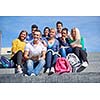 Group portrait  of happy  students outside sitting on steps have fun