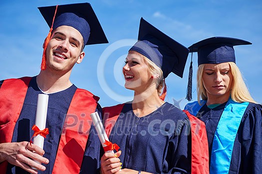 young graduates students group standing in front of university building on graduation day young graduates students group standing in front of university building on graduation day