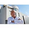 senior man in front of luxury modern home villa