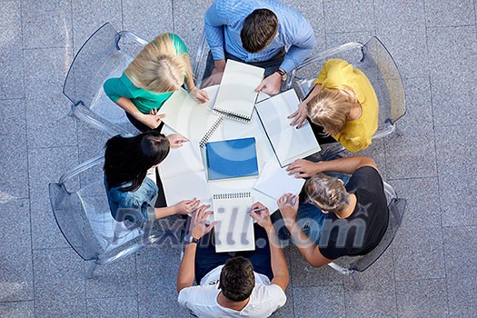 top view, group of students together at school table working homework and have fun top view, group of students together at school table working homework and have fun