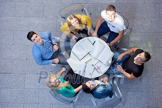 top view, group of students together at school table working homework and have fun top view, group of students together at school table working homework and have fun