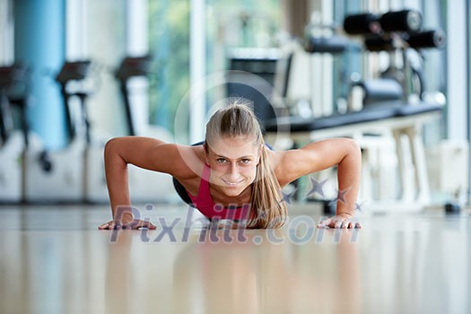 Gorgeous blonde woman warming up and doing some push ups a the gym Gorgeous blonde woman warming up and doing some push ups a the gym