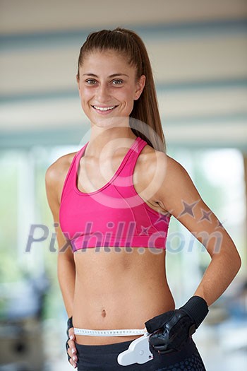 young fit woman measuring belly on a training in fitness gym young fit woman measuring belly on a training in fitness gym