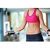 young fit woman measuring belly on a training  in  fitness gym