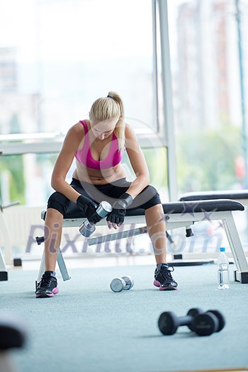 halethy young woman exercise with dumbells and relaxing on banch in fitness gym halethy young woman exercise with dumbells and relaxing on banch in fitness gym