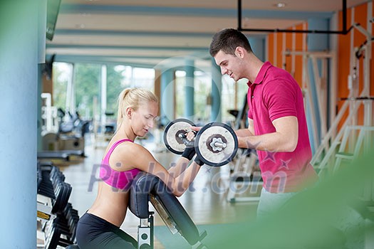 young sporty woman with trainer exercise weights lifting in fitness gym young sporty woman with trainer exercise weights lifting in fitness gym