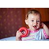 happy baby with first teeth smilling and play with toys