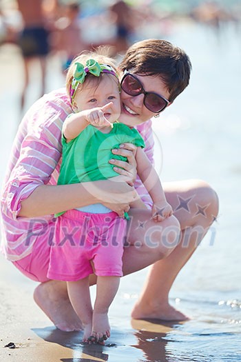 happy mom and baby on beach have fun while learning to walk and make first steps happy mom and baby on beach have fun while learning to walk and make first steps