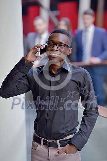 Happy smiling successful African American businessman in a suit in a modern bright office indoors Happy smiling successful African American businessman in a suit in a modern bright office indoors