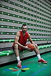 Basketball player portrait  on basketball court holding ball with black isolated background