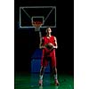 Basketball player portrait  on basketball court holding ball with black isolated background