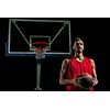 Basketball player portrait  on basketball court holding ball with black isolated background