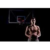 Basketball player portrait  on basketball court holding ball with black isolated background