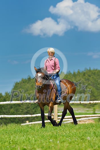 happy woman in sunglasses sitting on horse farm animal outdoors with blue sky in background happy woman in sunglasses sitting on horse farm animal outdoors with blue sky in background