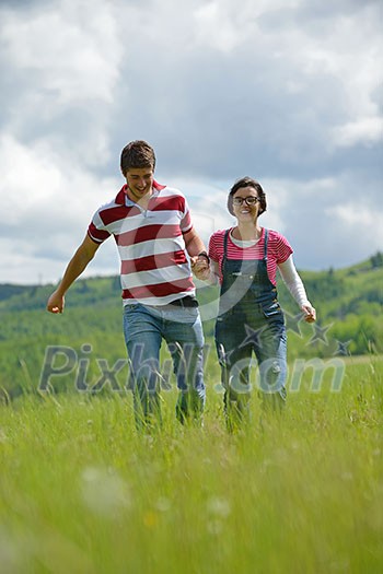 Portrait of romantic young couple in love smiling together outdoor in nature with blue sky in background Portrait of romantic young couple in love smiling together outdoor in nature with blue sky in background