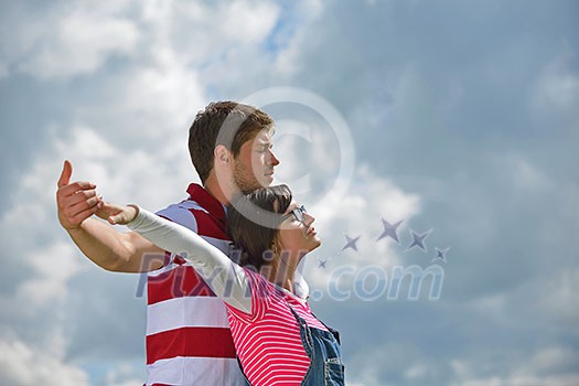 Portrait of romantic young couple in love smiling together outdoor in nature with blue sky in background Portrait of romantic young couple in love smiling together outdoor in nature with blue sky in background