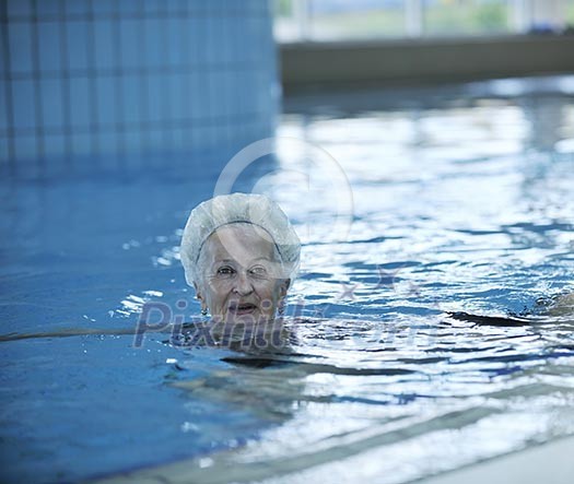beautiful old senior woman have fun and recreation on swimming pool beautiful old senior woman have fun and recreation on swimming pool