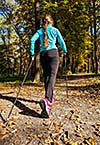 Nordic walking adventure and exercising concept - woman hiking withnordic walking poles in park