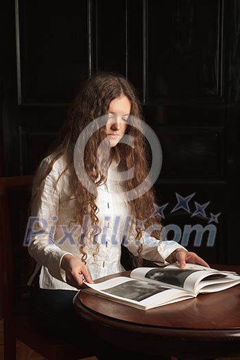 Young beautiful woman with long hairsreading a book
