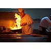 chef in hotel kitchen prepare vegetable  food with fire