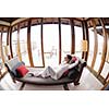 happy young woman relax at home on sofa in bright living room and watching tv