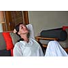 happy young woman relax at home on sofa in bright living room and watching tv